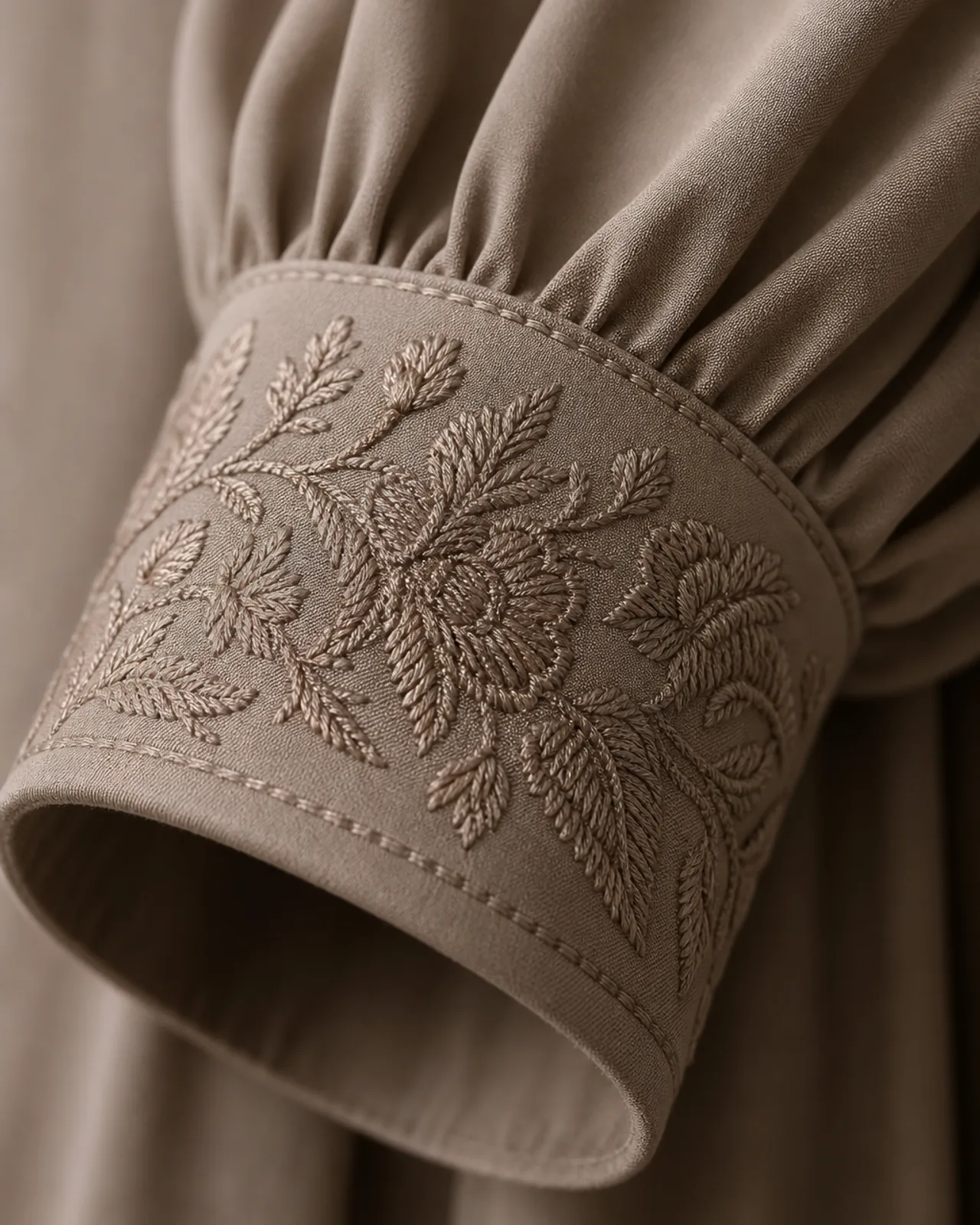 Cuff embroidery close-up showing stitch density, thread colour against the fabric and how the cuff edge is finished