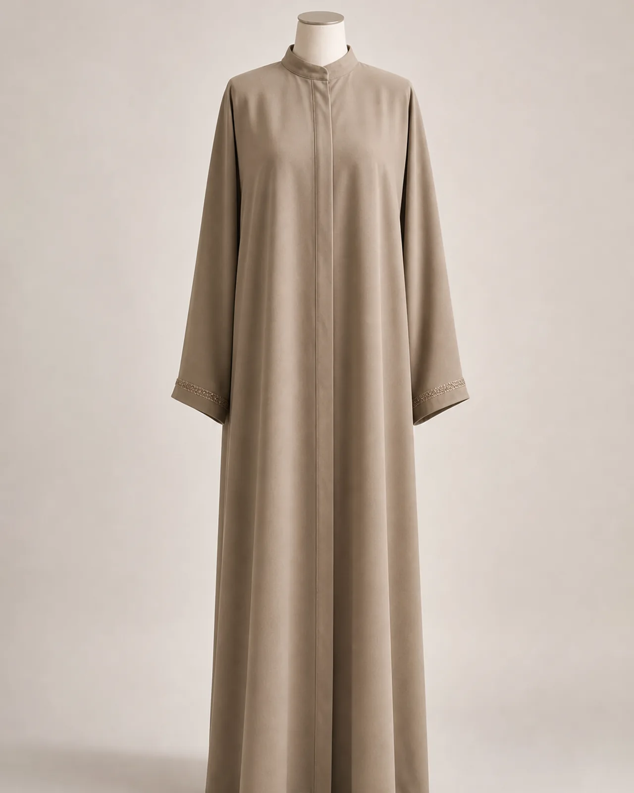Vorderansicht, ganzfigurig, schlichte Alltags-Abaya geschlossen getragen, gerader Saum, heller neutraler Studiohintergrund
