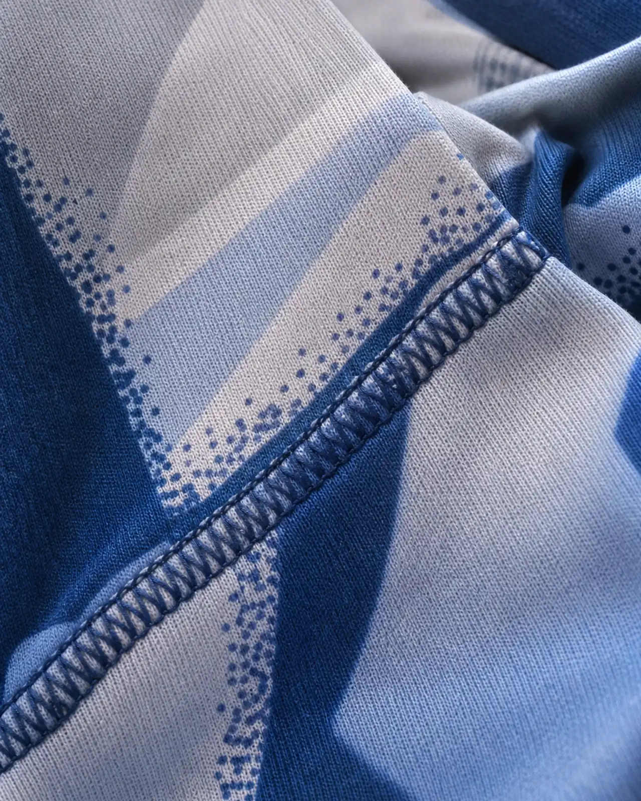 Detail of a printed jersey panel, showing print registration, stretch direction and colour depth on the knit