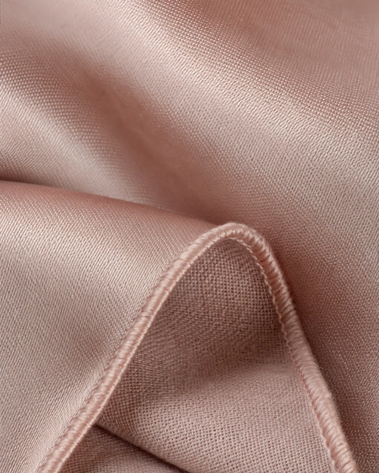 Satin close-up at roughly three times magnification, angled to show sheen, face and the reverse side of the cloth